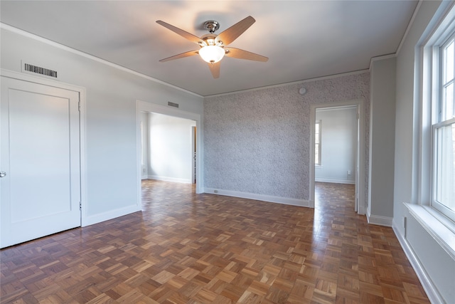 spare room with visible vents, baseboards, crown molding, and wallpapered walls