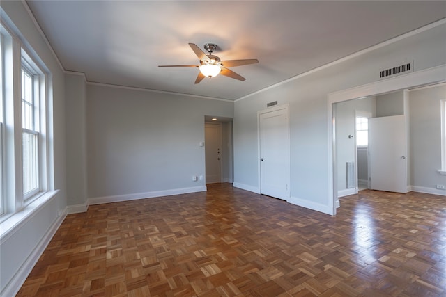 spare room with visible vents, ceiling fan, crown molding, and baseboards