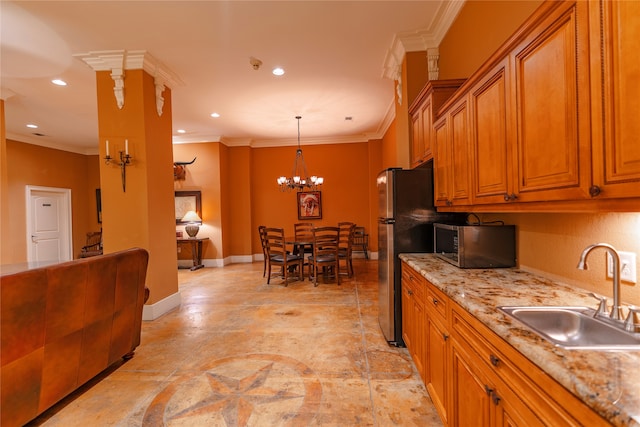 kitchen with sink, ornamental molding, pendant lighting, stainless steel appliances, and light stone countertops