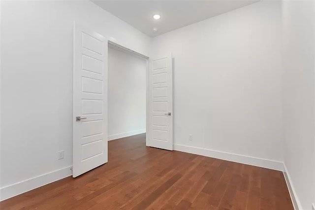 unfurnished bedroom with dark hardwood / wood-style flooring and a closet