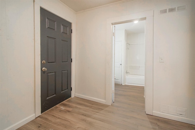 entryway featuring light wood-type flooring and ornamental molding