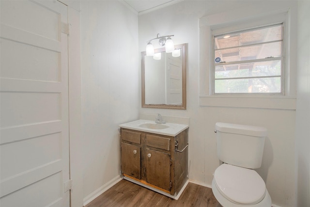 bathroom with hardwood / wood-style floors, vanity, toilet, and ornamental molding