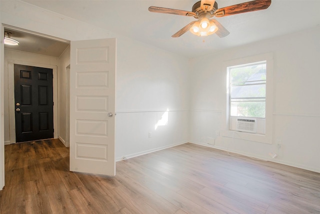 empty room with hardwood / wood-style floors, ceiling fan, and cooling unit