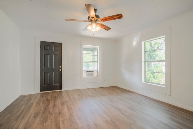 spare room featuring light hardwood / wood-style flooring, ceiling fan, and a healthy amount of sunlight