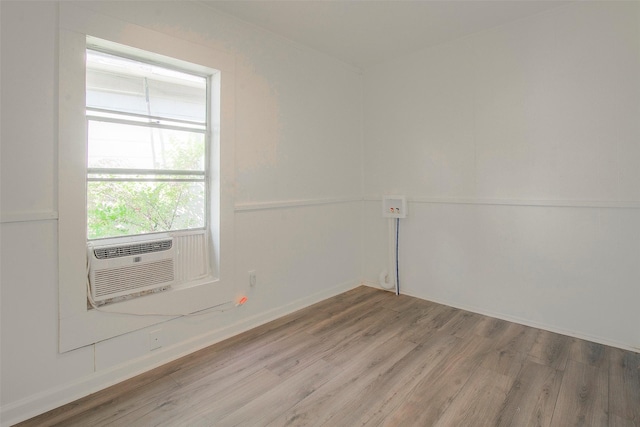 spare room with cooling unit and hardwood / wood-style flooring