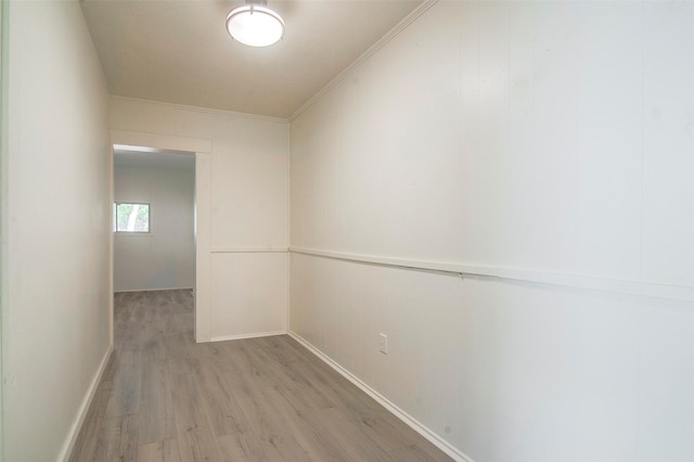 hallway featuring crown molding and light hardwood / wood-style flooring