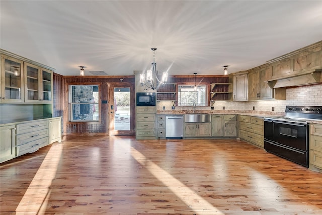 kitchen with pendant lighting, black appliances, sink, green cabinetry, and light wood-type flooring