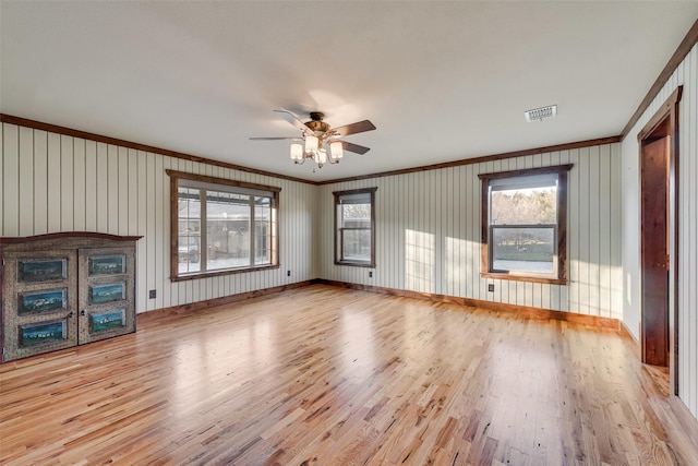 empty room with ornamental molding, ceiling fan, and light hardwood / wood-style floors