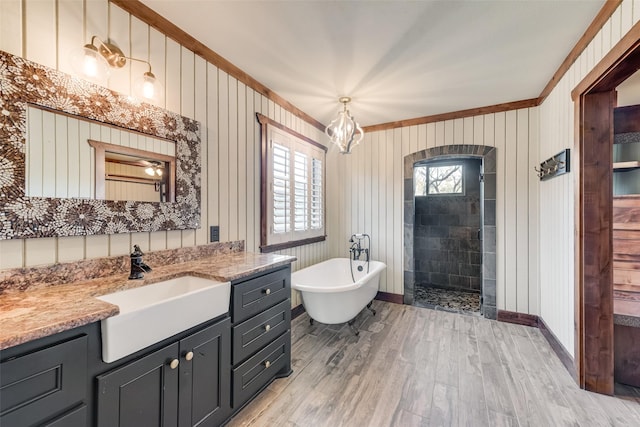 bathroom with a healthy amount of sunlight, independent shower and bath, wood-type flooring, and vanity