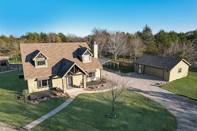 view of front of property featuring a porch, an outbuilding, a front yard, and a garage