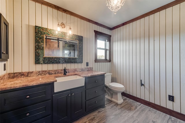 bathroom featuring vanity, hardwood / wood-style flooring, toilet, and an inviting chandelier