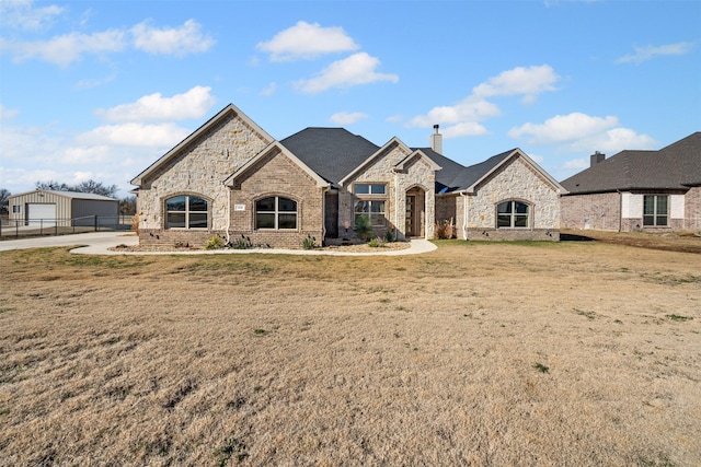 french provincial home with a front yard and a garage