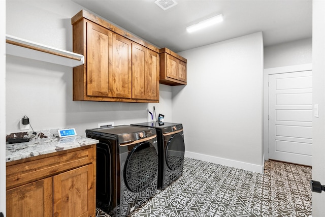 washroom featuring washer and clothes dryer and cabinets