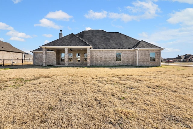 rear view of property featuring a yard