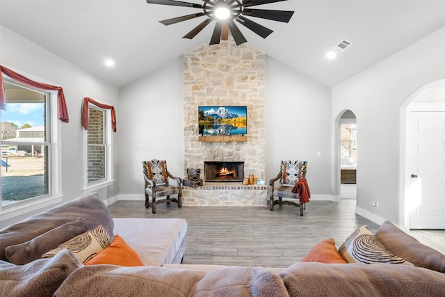 living room featuring a fireplace, vaulted ceiling, and ceiling fan