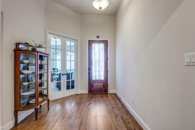 entrance foyer featuring french doors, a towering ceiling, and wood-type flooring