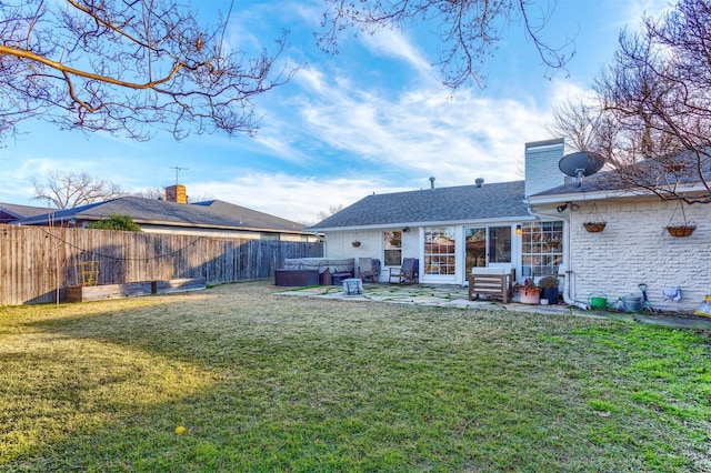 back of property featuring a lawn, a patio, and a hot tub