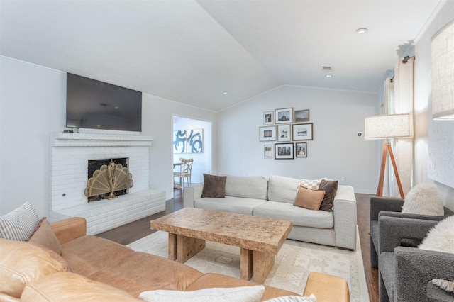 living room with lofted ceiling, a fireplace, and light hardwood / wood-style flooring