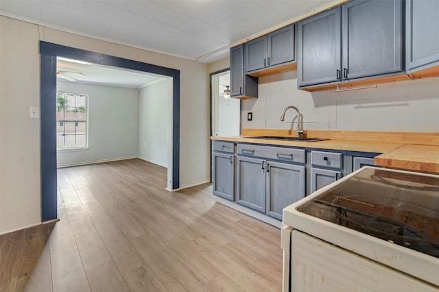 kitchen featuring crown molding, sink, electric range, light wood-type flooring, and butcher block counters