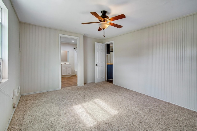 unfurnished bedroom with connected bathroom, carpet floors, ceiling fan, and crown molding