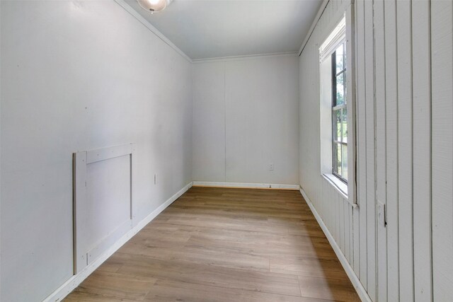 empty room featuring light hardwood / wood-style floors and crown molding