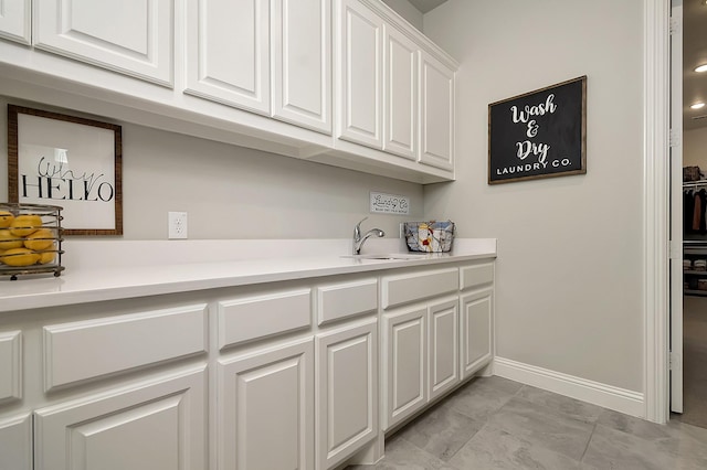 laundry room featuring sink and light tile patterned floors