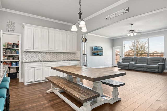 dining area featuring ornamental molding, ceiling fan with notable chandelier, and wood finished floors