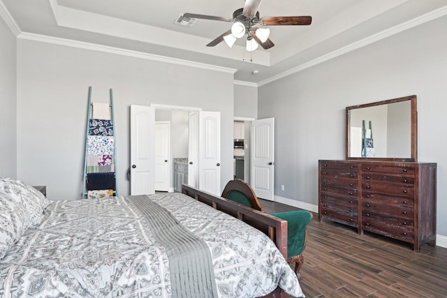 bedroom featuring visible vents, dark wood finished floors, baseboards, a tray ceiling, and crown molding