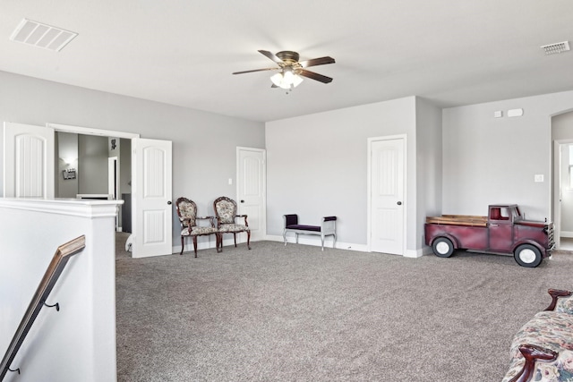 sitting room with a ceiling fan, visible vents, and carpet flooring