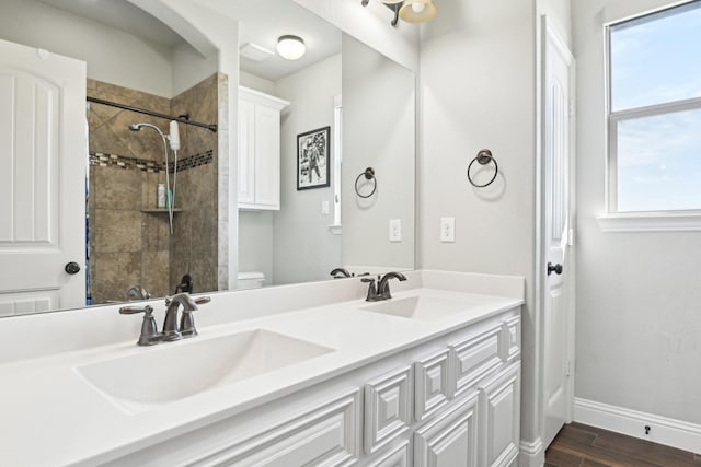 bathroom featuring a healthy amount of sunlight, a sink, and baseboards
