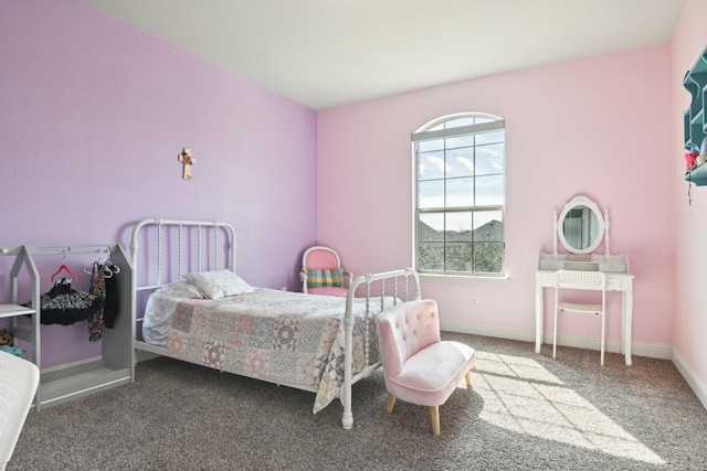 bedroom with dark carpet and baseboards