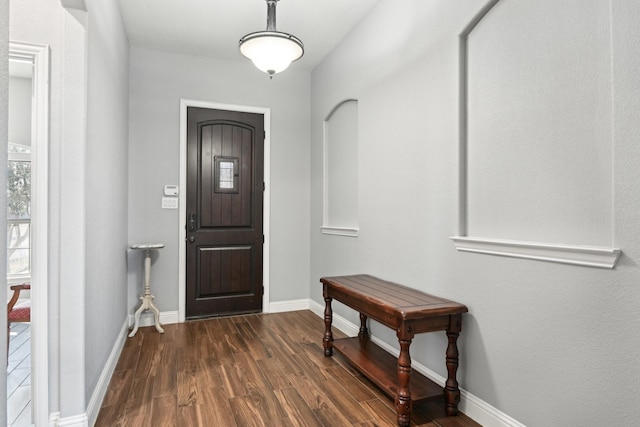entrance foyer with dark wood finished floors and baseboards