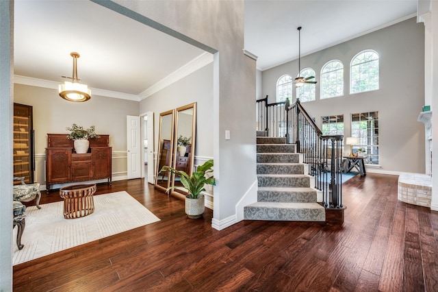 entryway with dark hardwood / wood-style floors, ceiling fan, and ornamental molding