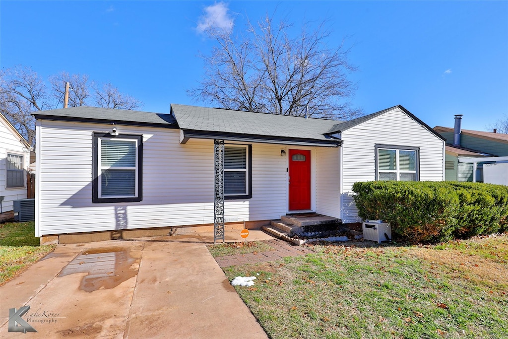 view of front of house featuring a front lawn and central air condition unit