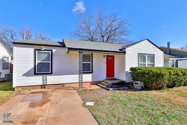 view of front of house featuring a front lawn and central air condition unit