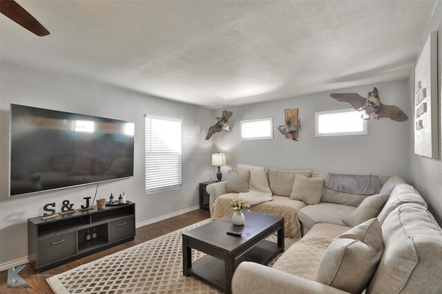 living room with ceiling fan and dark wood-type flooring