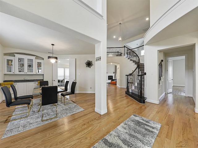 dining area featuring a high ceiling, an inviting chandelier, and light hardwood / wood-style floors