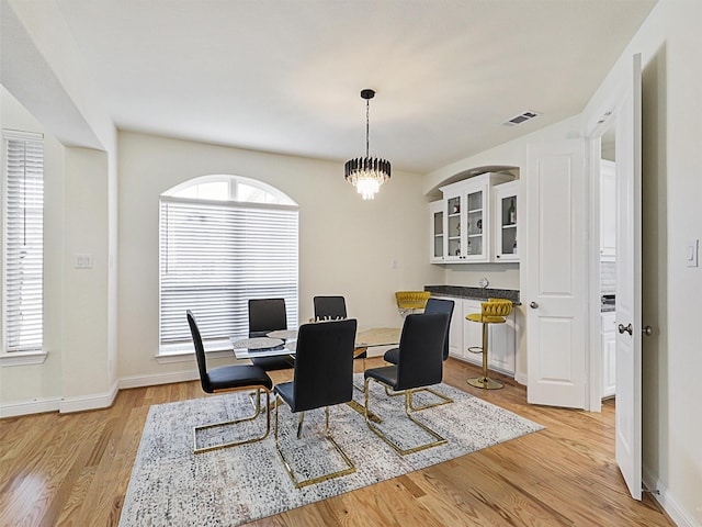 dining area featuring light hardwood / wood-style floors and a chandelier