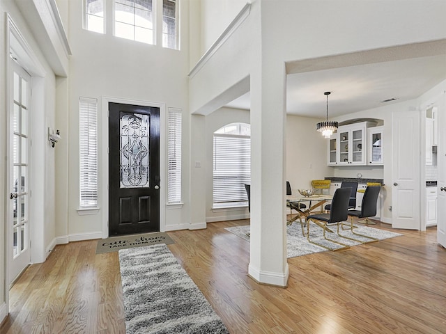 entrance foyer with light hardwood / wood-style floors and a chandelier