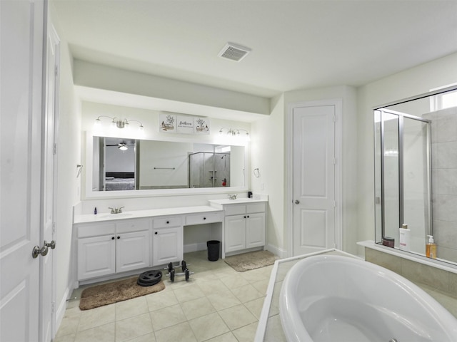 bathroom featuring tile patterned flooring, shower with separate bathtub, and vanity