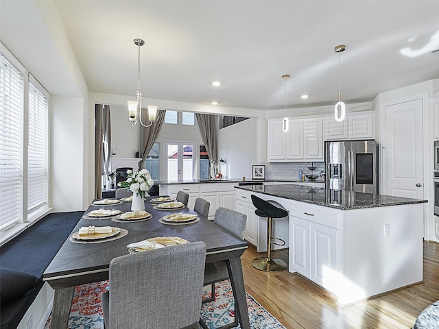 dining area with a notable chandelier, light hardwood / wood-style floors, and sink