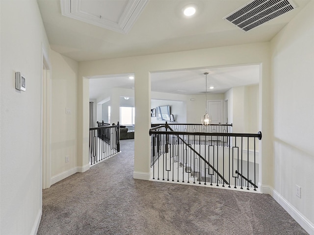 hall with ornamental molding and carpet flooring