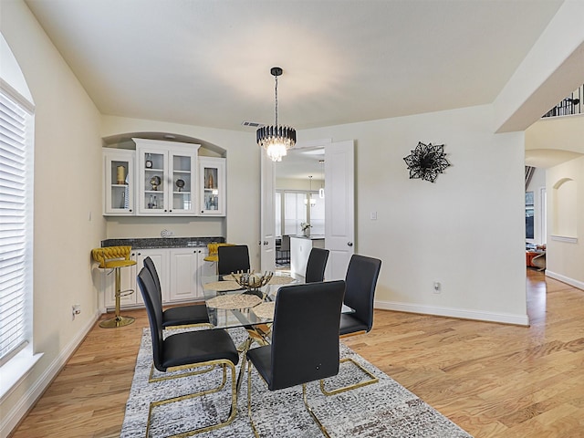 dining space featuring an inviting chandelier, light hardwood / wood-style flooring, and a healthy amount of sunlight