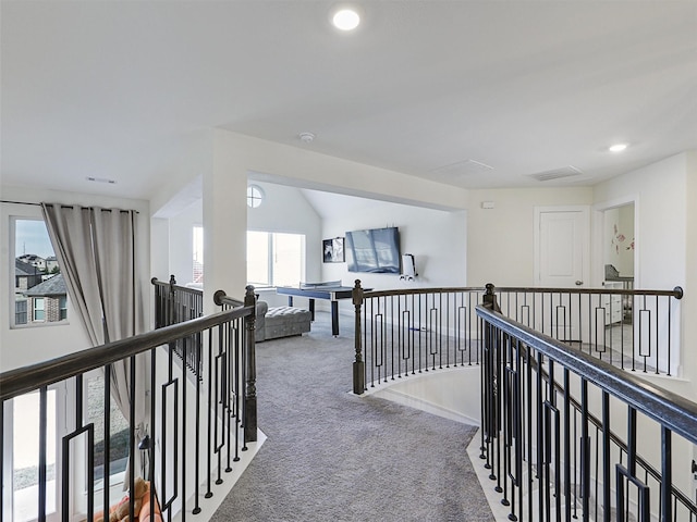 hall featuring vaulted ceiling and carpet flooring