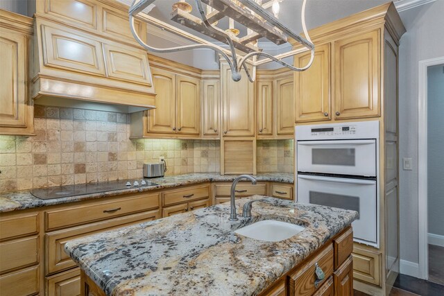 kitchen with double oven, light stone countertops, sink, and black electric stovetop