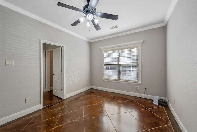 empty room featuring ceiling fan, dark tile patterned flooring, and ornamental molding