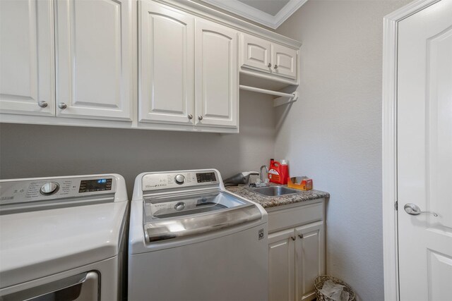 washroom with washer and clothes dryer, sink, cabinets, and crown molding