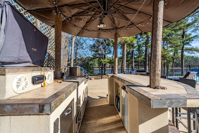 view of patio / terrace with a grill, a bar, and exterior kitchen