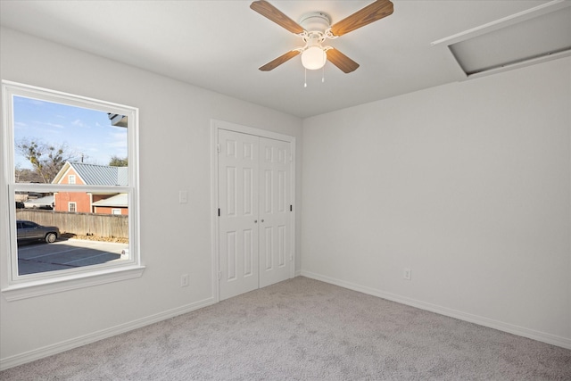 unfurnished bedroom featuring light carpet, a closet, and ceiling fan