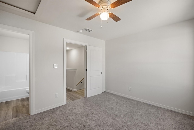 unfurnished bedroom featuring ensuite bathroom, light carpet, and ceiling fan